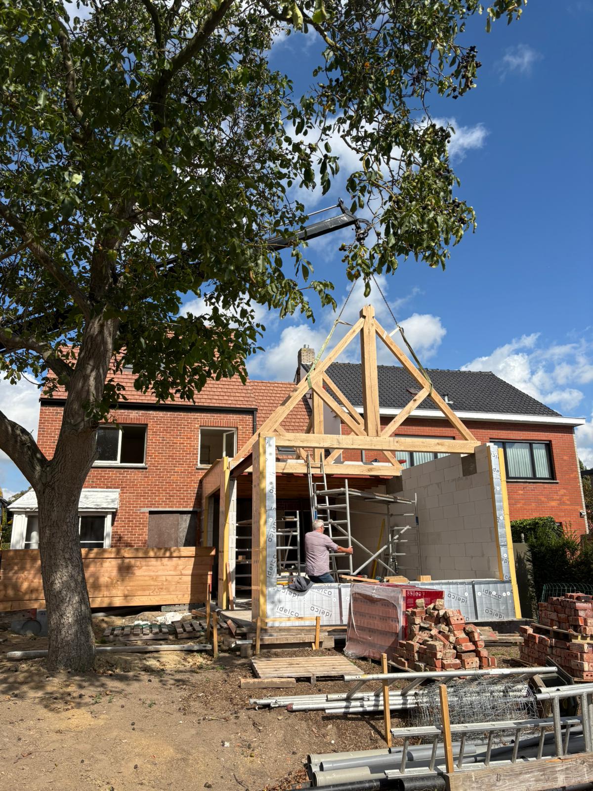 Houten spant wordt met de kraan geplaatst